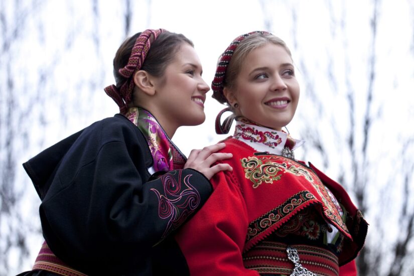 Sort beltestakk jakke og rød Øst-Telemark jakke på to jenter